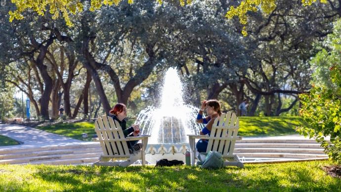 两个学生坐在米勒喷泉前的阿迪朗达克椅子上